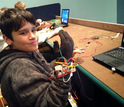 child with laptop and wires on a hand